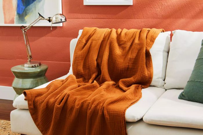 The Quince Organic Airy Gauze Blanket draped gracefully over a couch