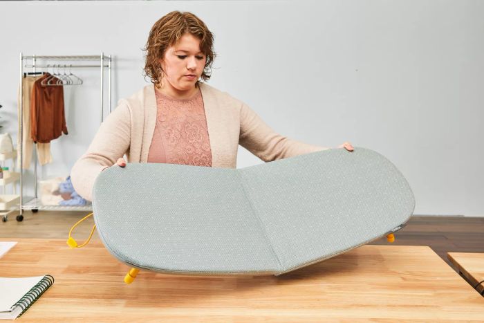 A person unfolding the Joseph Joseph Pocket Folding Ironing Board