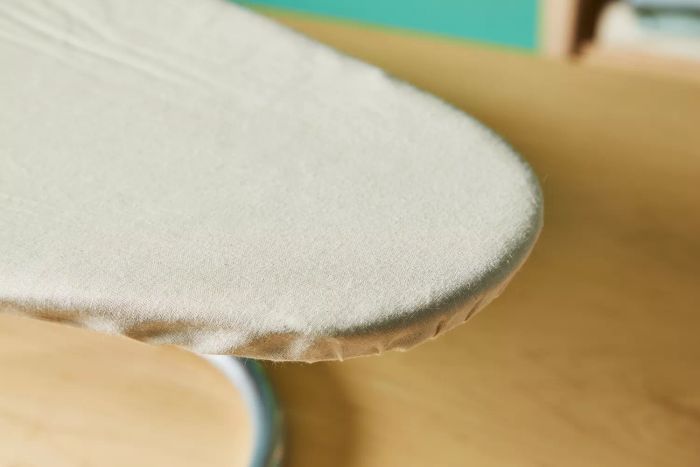 A close-up shot capturing the edge of the Household Essentials 131210 Small Steel Table Top Ironing Board with Iron Rest.