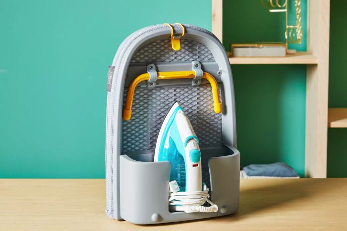 A closed Joseph Joseph Pocket Plus Folding Ironing Board resting on a wooden counter