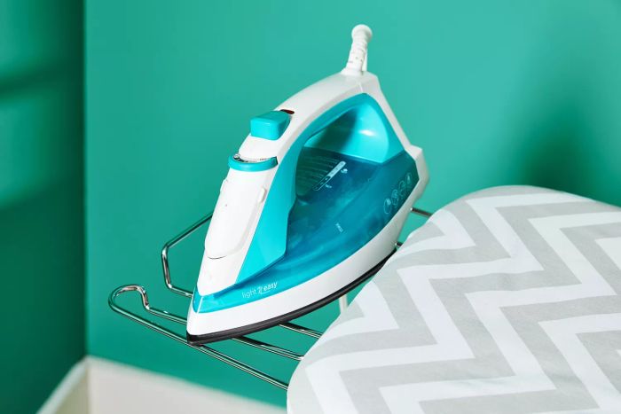 An iron resting on the metal details of the Amazon Basics Full-Size Ironing Board, highlighting its sturdy design.
