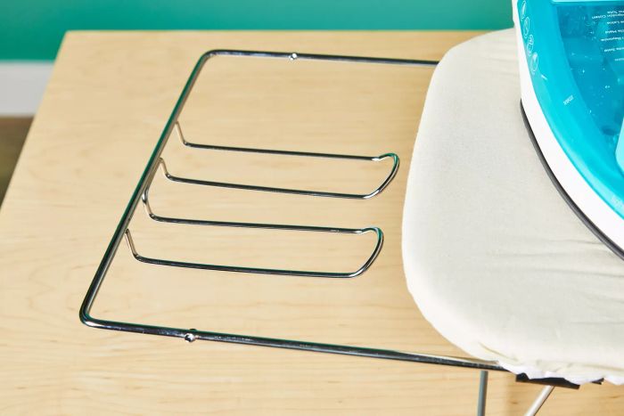 A detailed close-up showing the metal components of the Household Essentials 131210 Small Steel Table Top Ironing Board with Iron Rest.