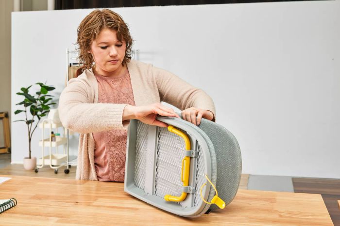 A person setting up the Joseph Joseph Pocket Folding Ironing Board