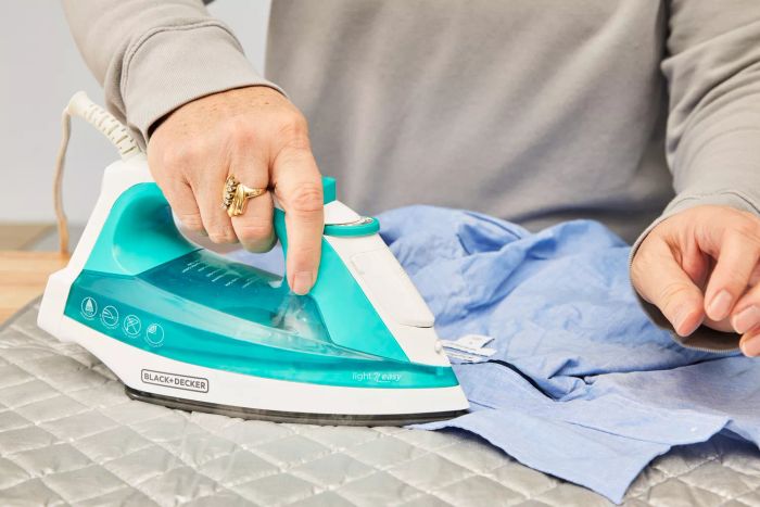 A close-up shot of someone ironing on the BNYD Portable Ironing Mat Blanket