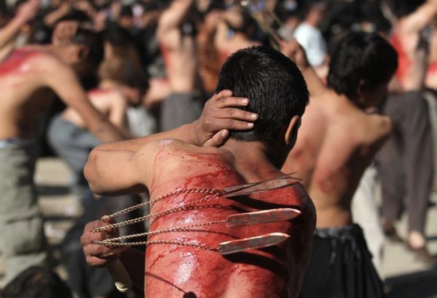 199920-Shia-Muslims-Flagellate-Themselves-Walk-On-Fire-Prior-To-Ashura