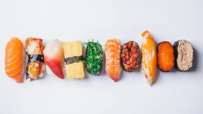 Aerial perspective of assorted sushi arranged on a white backdrop