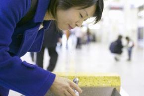 A woman drinking water from a fountain