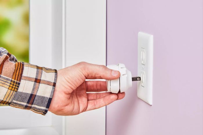 A person connecting the Enviroscent Plug Hub Starter Kit to a wall socket