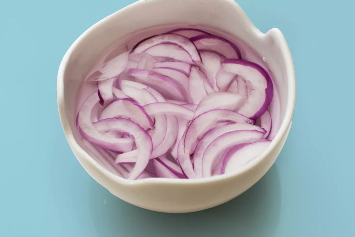 onions submerged in a bowl of water
