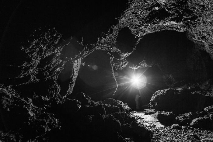 A shadowy cave with a distant light shining