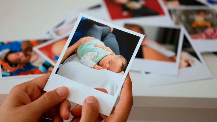 A person holding a freshly developed instant photograph