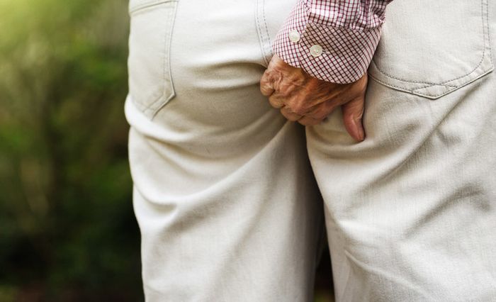 A person scratching their anus.