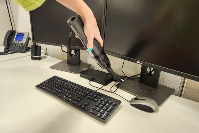 The Brigii M5 Cordless Crevice Vacuum in action, cleaning an office desk