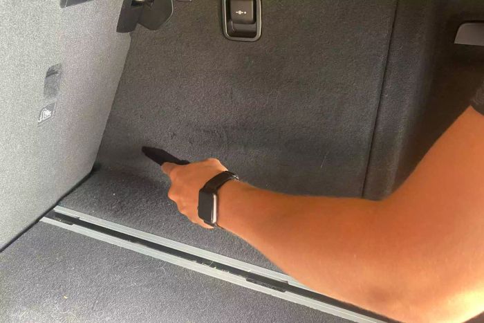 The Worx Power Share Cordless Cube Vac Compact Vacuum in action, cleaning a car floor.