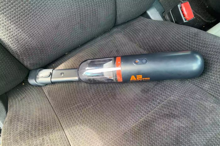 The Baseus A2 Pro Car Vacuum Cleaner in action, cleaning a car interior