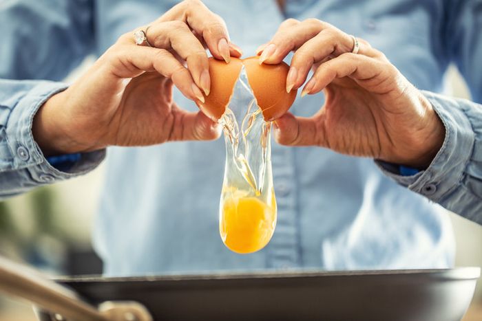 A person cracking an egg