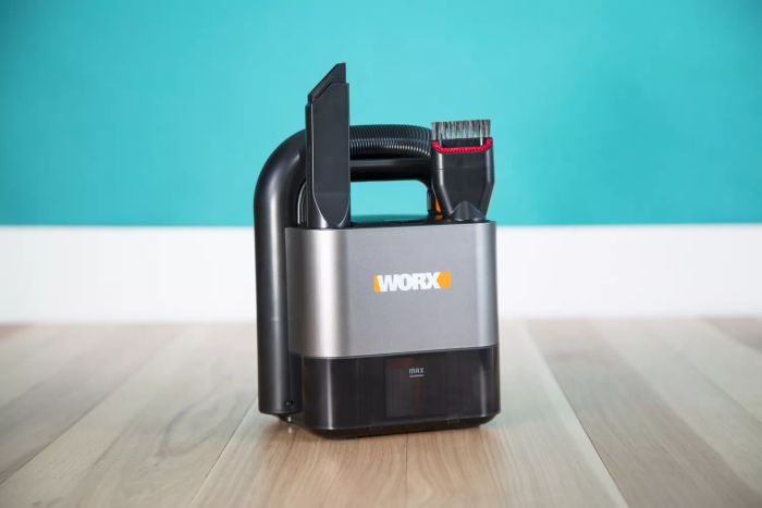 The Worx Power Share Cordless Cube Vac Compact Vacuum placed on wooden flooring against a blue backdrop