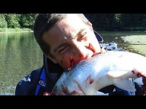 A man biting into a fish, fiercely