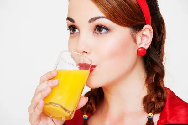 A girl in red drinking juice