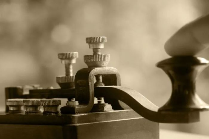 A detailed view of a finger pressing a telegraph transmitter