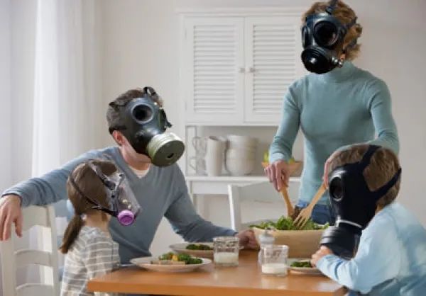 A family indoors wearing gas masks to survive the poor-quality air