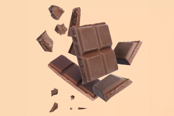 slices of a chocolate bar arranged on a soft peach-colored surface