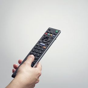 A hand gripping a remote control