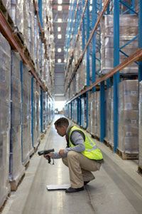A warehouse worker scans pallets.