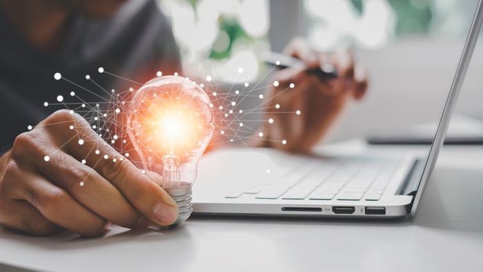 A hand holding a light bulb symbolizing inspiration and creativity.