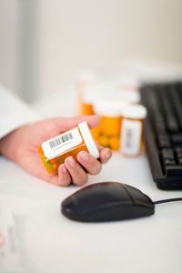 Pharmacist scanning a barcode on a pill bottle.