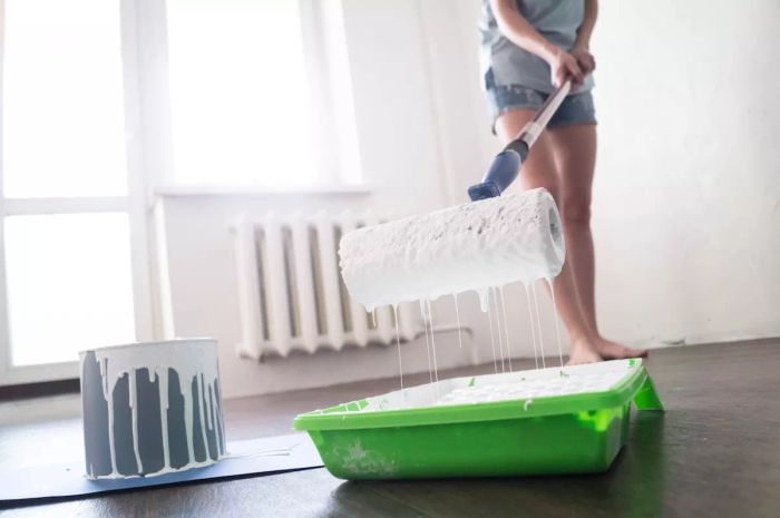 Painting Tips: A woman painting a room with a roller.