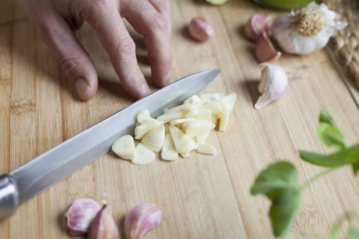 Preparing a homemade dish in the kitchen, garlic sliced for marination.