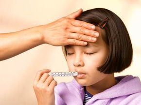 A girl feeling unwell with a thermometer in her mouth