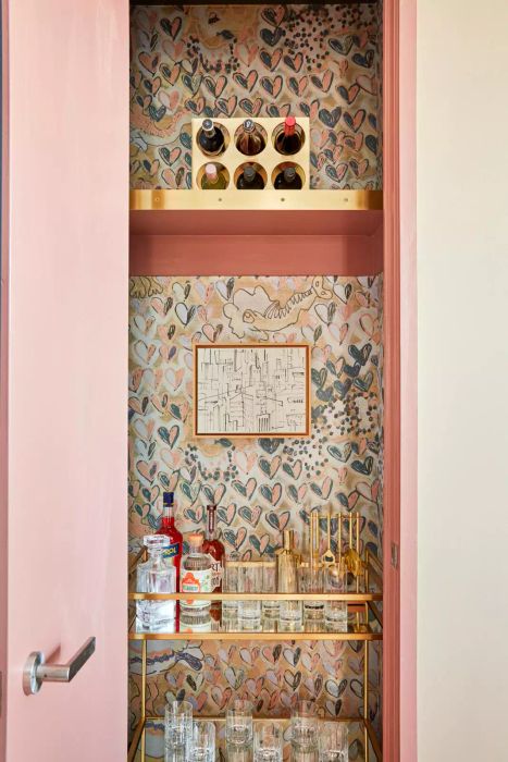 A closet transformed into a stylish haven with wallpapered interiors.