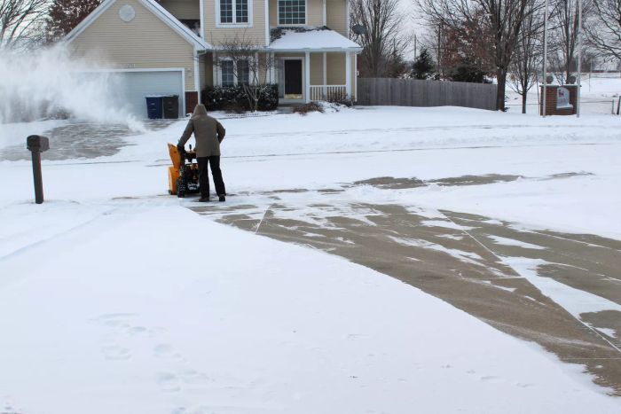 A person using the Cub Cadet 2X 26-Inch IntelliPower Snow Blower to clear snow.