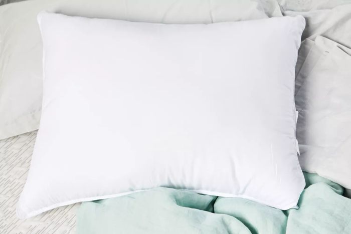 The Amazon Basics Down-Alternative Pillow placed on a bed