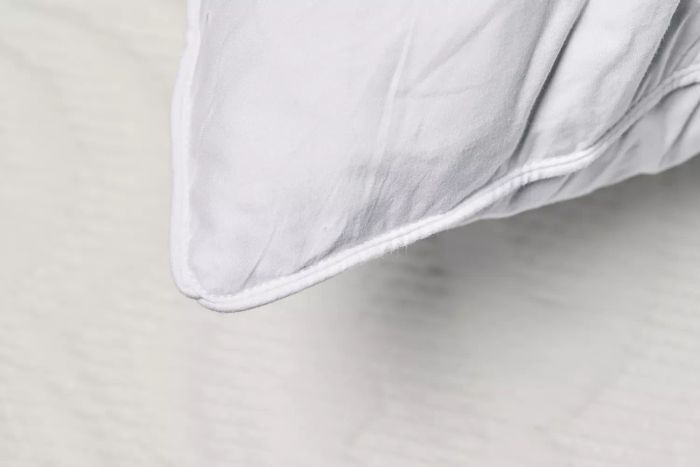 A close-up of the corner seam on the Puredown Feathers Blend Pillow