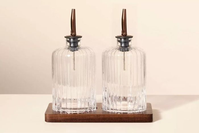 The Target Hearth & Hand with Magnolia Oil & Vinegar Ribbed Glass Bottle Set combines a charming ribbed design with a wooden base, offering both style and convenience for your kitchen essentials.