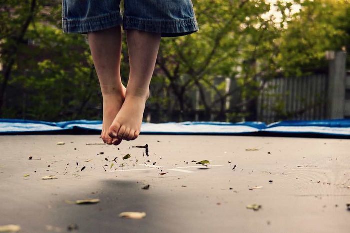 A child’s feet soaring above a trampoline