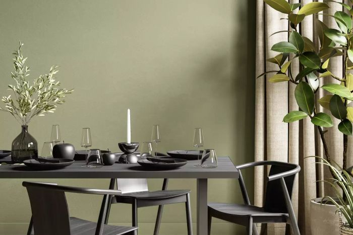 A cozy green-themed interior featuring a dining table, plants, and decorative elements. 3D render mockup.