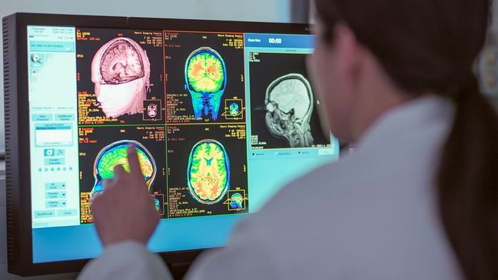 A female doctor in North Yorkshire, UK, examines an MRI scanner monitor.