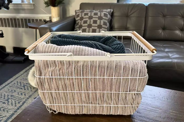 Yamazaki Tosca Wire Basket filled with clothes placed on a wooden table during testing