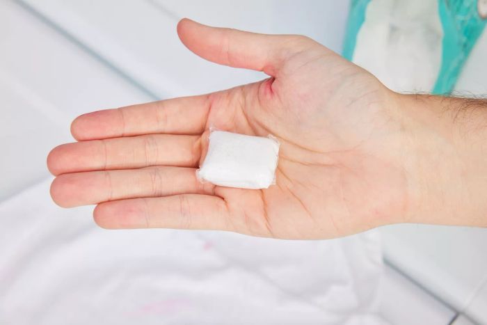 A person is shown holding a pod of Mrs. Meyer’s Clean Day Laundry Detergent Pacs.