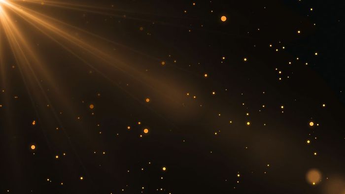 A beam of light descends, casting a glow on golden particles suspended in the air