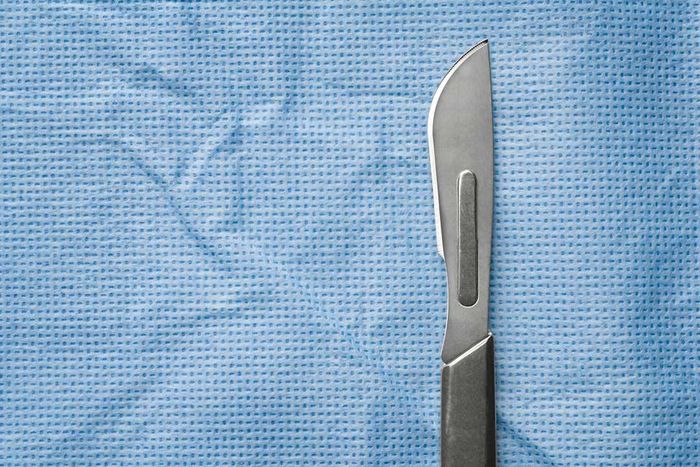 Scalpel resting on surgical fabric
