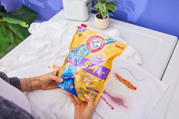 A person is holding a pack of Arm & Hammer Plus OxiClean Odor Blasters 5-In-1 Power Paks