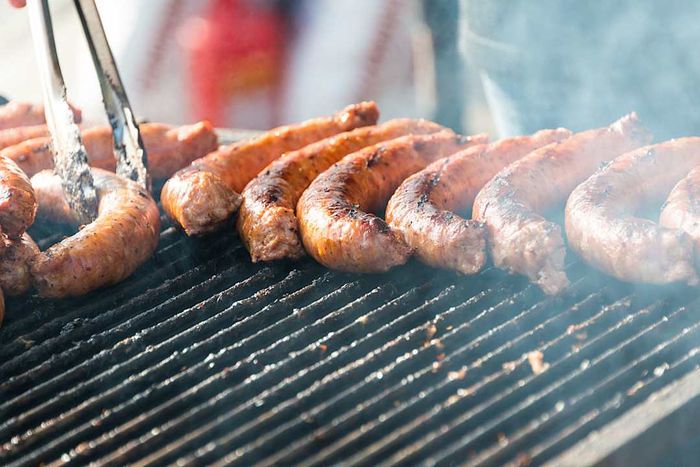 Bratwursts sizzling on a grill