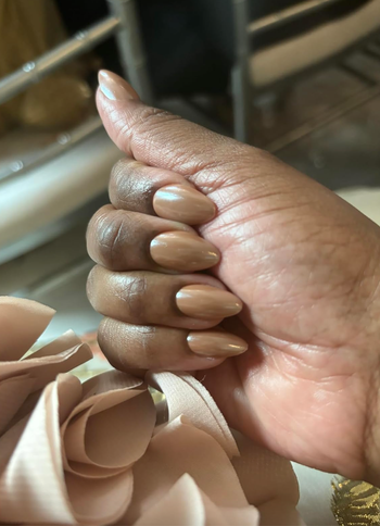 Close-up view of a hand with long, almond-shaped, perfectly manicured nails