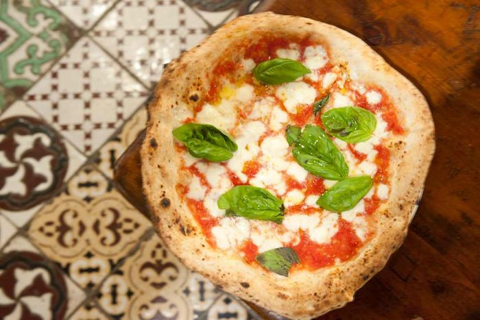 Margherita pizza displayed on tiles