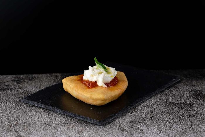 Fried Pizza Margherita on a black stone cutting board, Italy